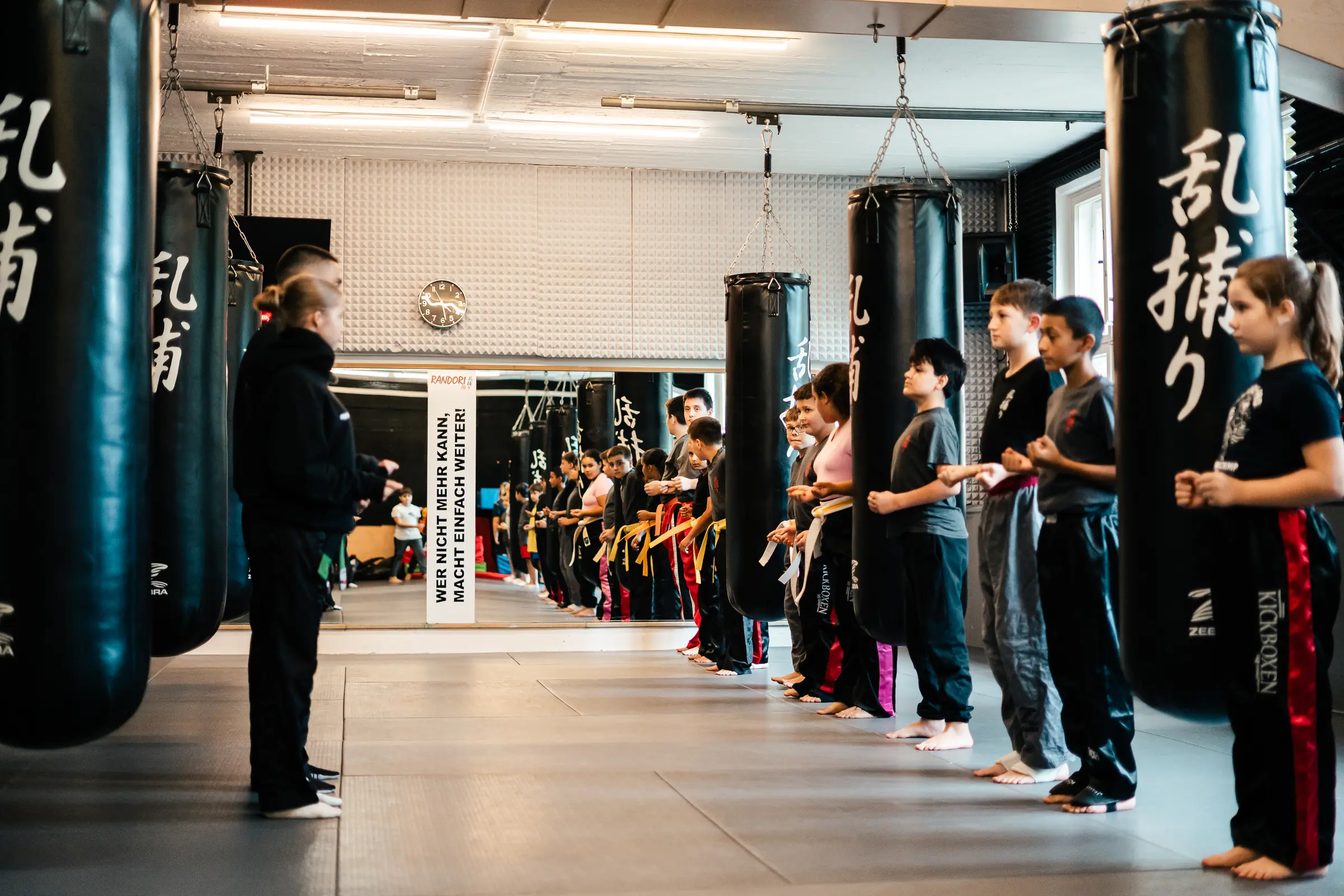 Kickbox-Training für Kinder in Spandau: Die Gruppe steht zwischen den Sandsäcken in einer Reihe