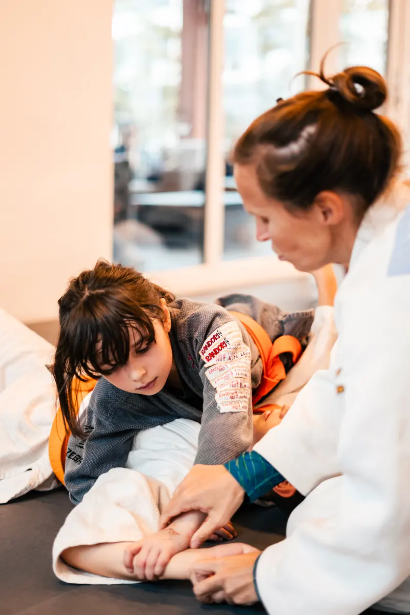 Judo: Ein Mädchen übt mit einer Erwachsenen eine Technik am Boden