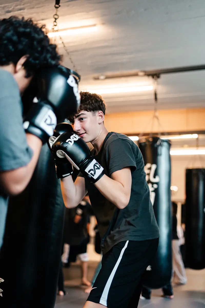 Jugendlicher mit Boxhandschuhen in Deckung beim Partnertraining