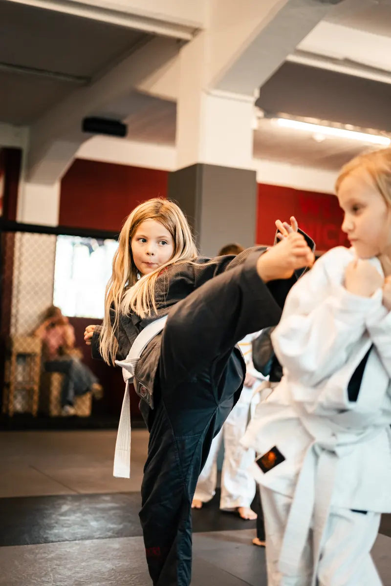 Zwei Mädchen im Kampfanzug beim Tritt-Training