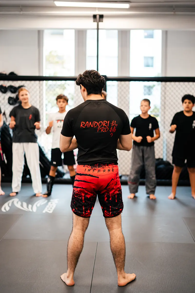 MMA-Training für Kinder und Jugendliche, ein Trainer steht vor der Gruppe